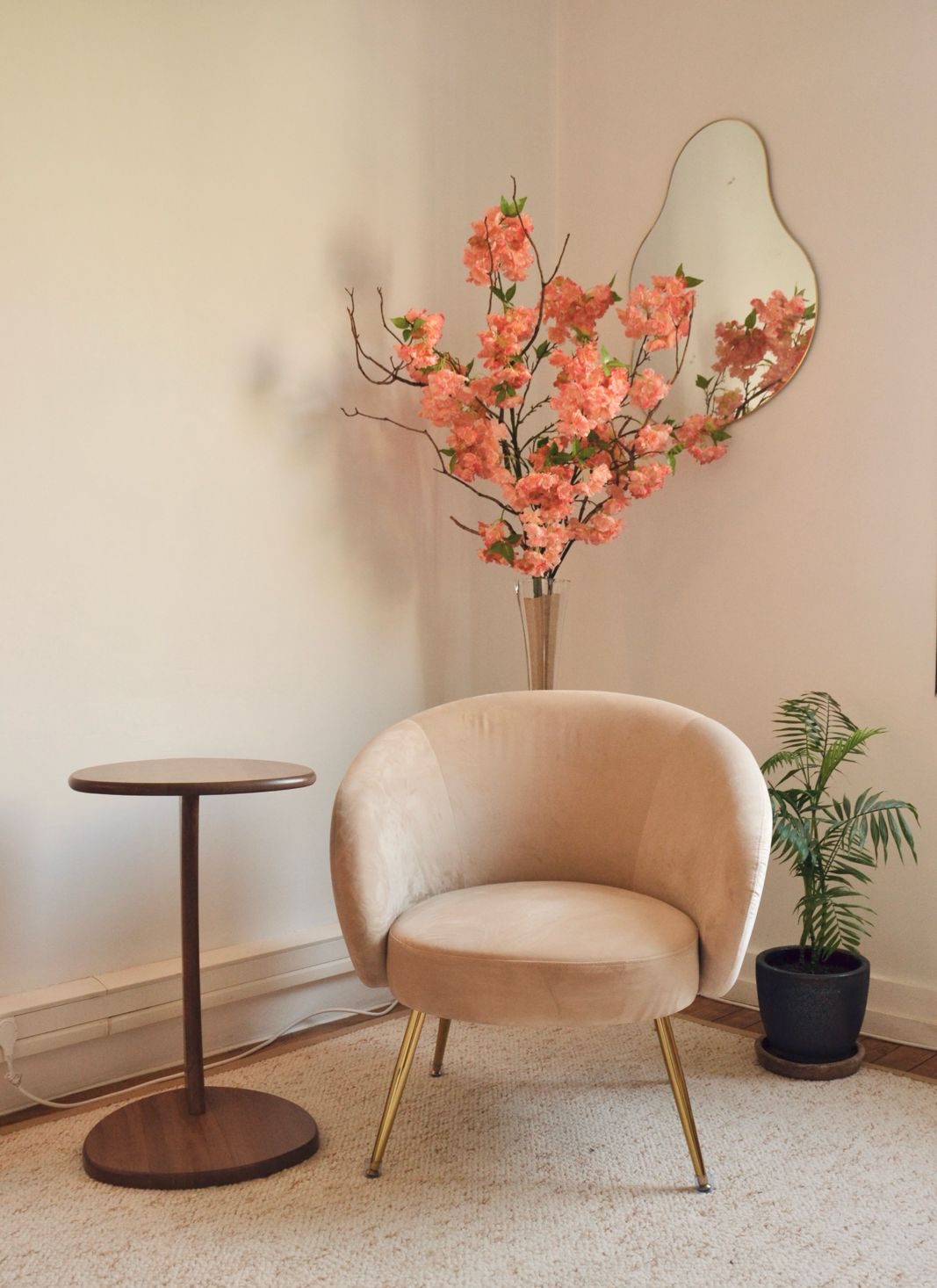 Le cabinet : deux fauteuils clairs de part et d'autre de deux guéridons en bois, un tapis écru, un lampadaire et des plantes.